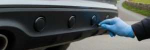 Parking sensors fitted in Bradford on the rear of a car by a technician.